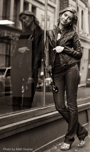 olga leaning against bulding window with reflection in black and white